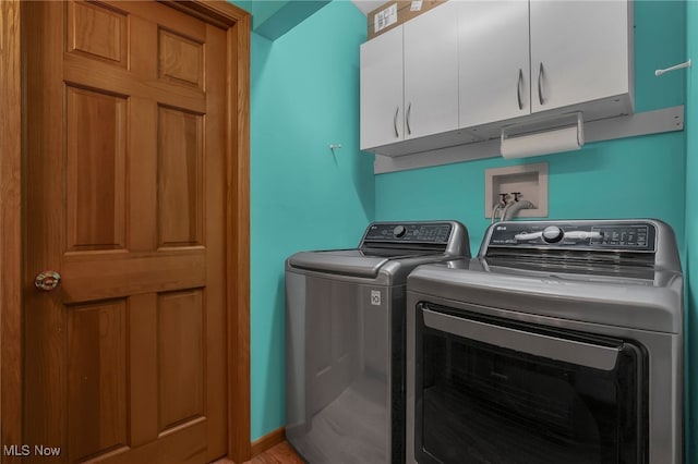 clothes washing area featuring washer and dryer and cabinets