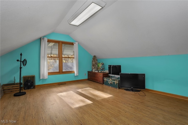 bonus room with light hardwood / wood-style floors and lofted ceiling