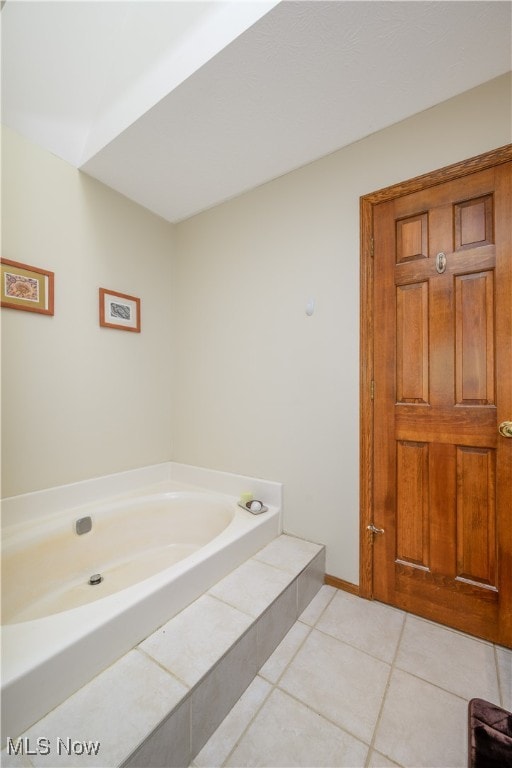 bathroom featuring tile patterned floors and a tub to relax in