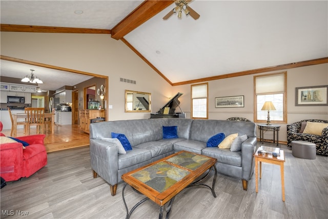 living room featuring hardwood / wood-style floors, lofted ceiling with beams, and ceiling fan with notable chandelier