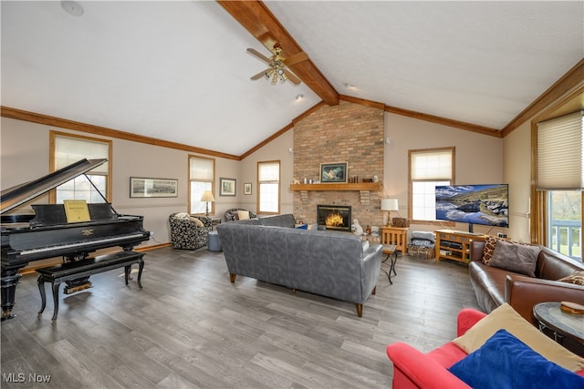 living room featuring ceiling fan, lofted ceiling with beams, a brick fireplace, and hardwood / wood-style floors