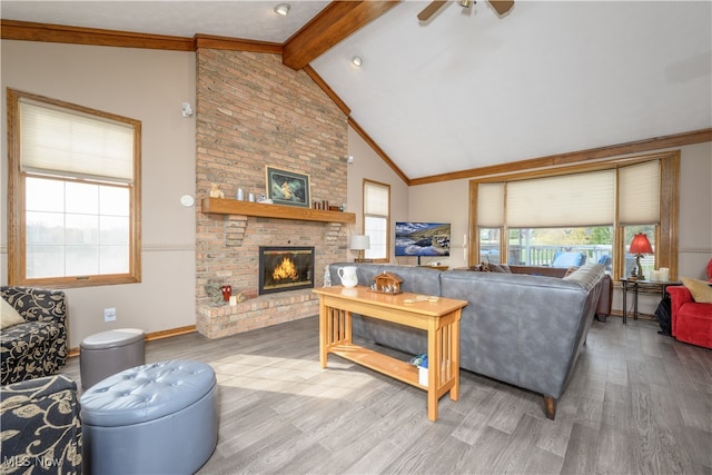 living room featuring hardwood / wood-style flooring, a healthy amount of sunlight, a fireplace, and lofted ceiling with beams