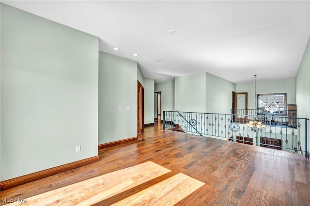 empty room featuring hardwood / wood-style floors and a chandelier