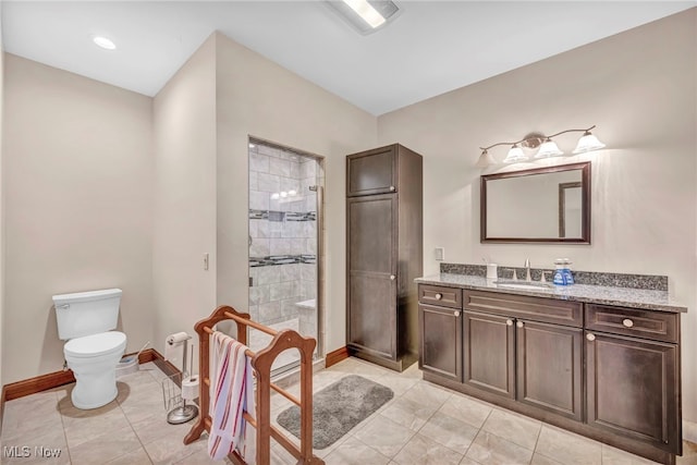 bathroom with vanity, toilet, and tiled shower