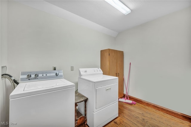 laundry area featuring washer and clothes dryer and light hardwood / wood-style floors