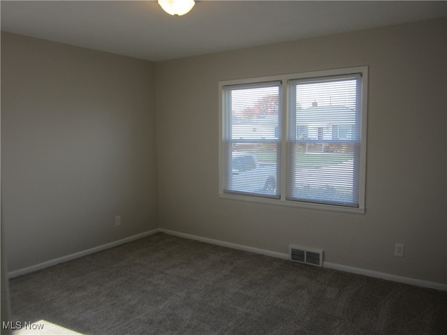 unfurnished room with dark carpet