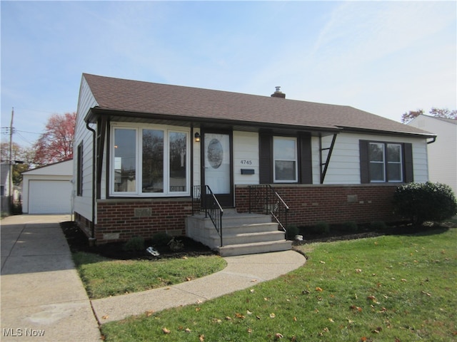 view of front facade featuring a garage, a front yard, and an outbuilding