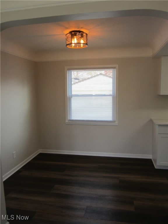 unfurnished dining area with dark wood-type flooring