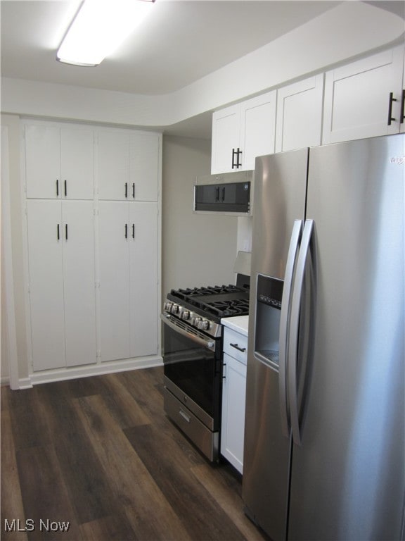 kitchen featuring stainless steel appliances, dark hardwood / wood-style floors, and white cabinetry