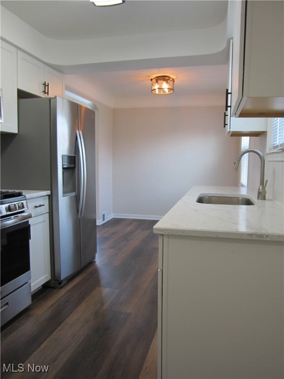 kitchen featuring white cabinets, appliances with stainless steel finishes, dark wood-type flooring, and sink