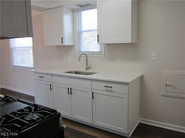 kitchen featuring white cabinetry, black range with gas stovetop, sink, and dark hardwood / wood-style floors