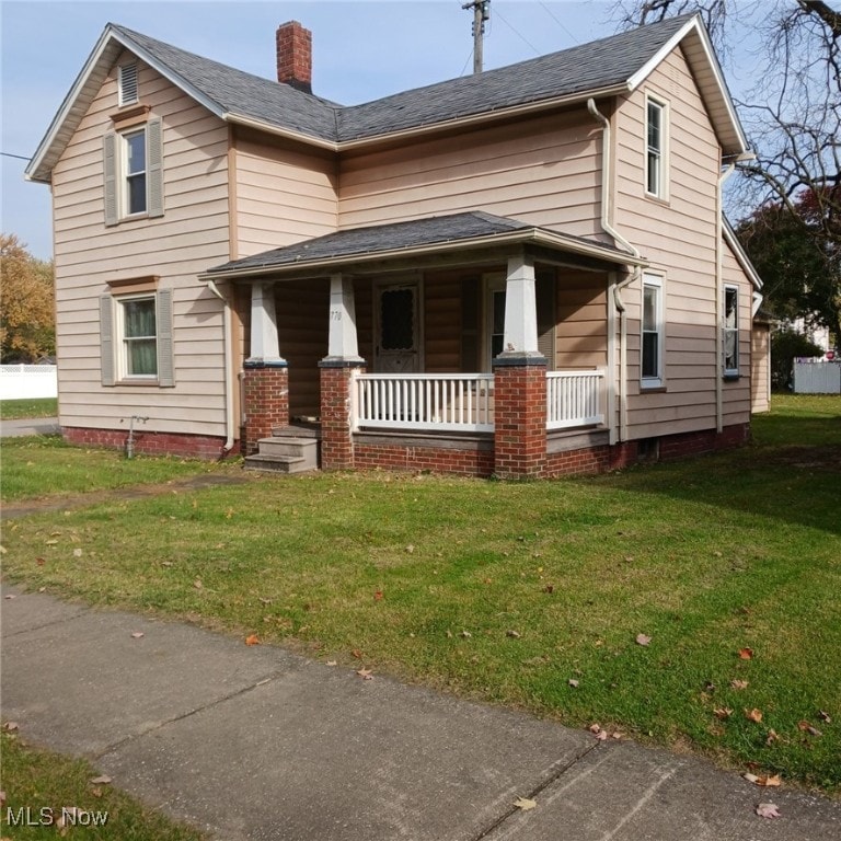 view of front of home with covered porch and a front yard