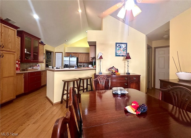 dining space featuring vaulted ceiling, light hardwood / wood-style flooring, and ceiling fan