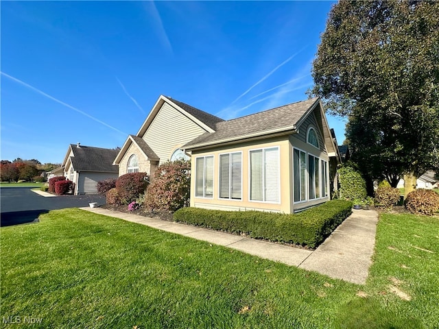 view of side of property with a garage and a lawn