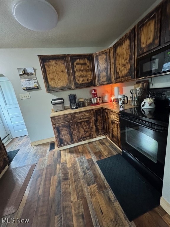 kitchen featuring dark hardwood / wood-style floors, black appliances, dark brown cabinets, and a textured ceiling