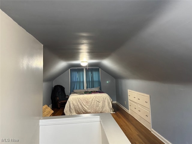 bedroom with dark wood-type flooring and vaulted ceiling