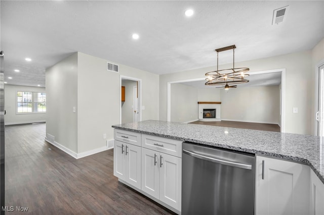 kitchen with white cabinetry, light stone counters, stainless steel dishwasher, dark hardwood / wood-style floors, and pendant lighting