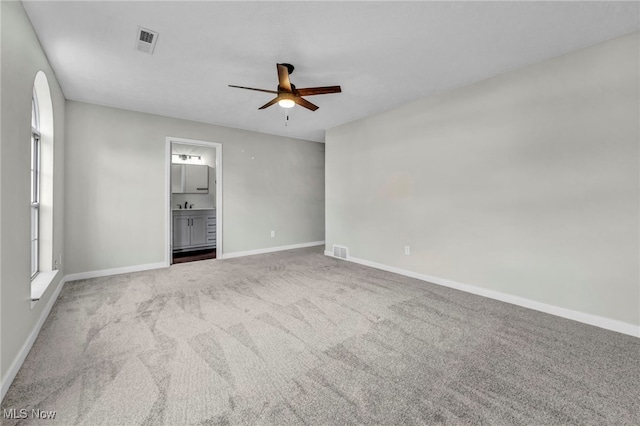 carpeted spare room featuring ceiling fan