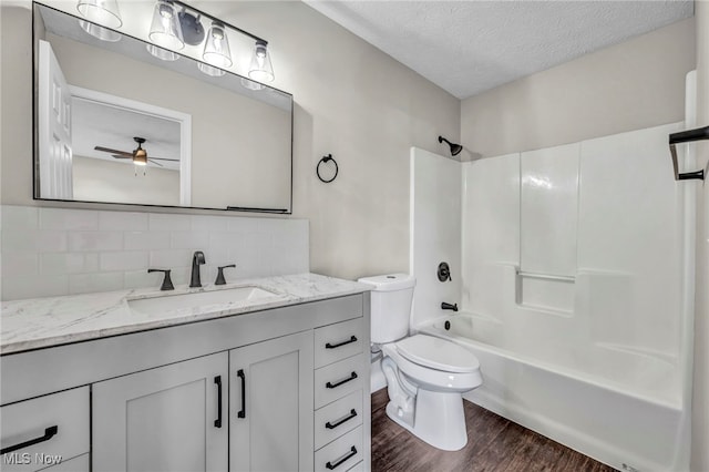 full bathroom featuring shower / bath combination, backsplash, hardwood / wood-style floors, a textured ceiling, and toilet