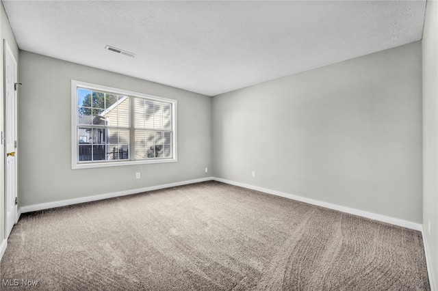 unfurnished room featuring a textured ceiling and carpet flooring