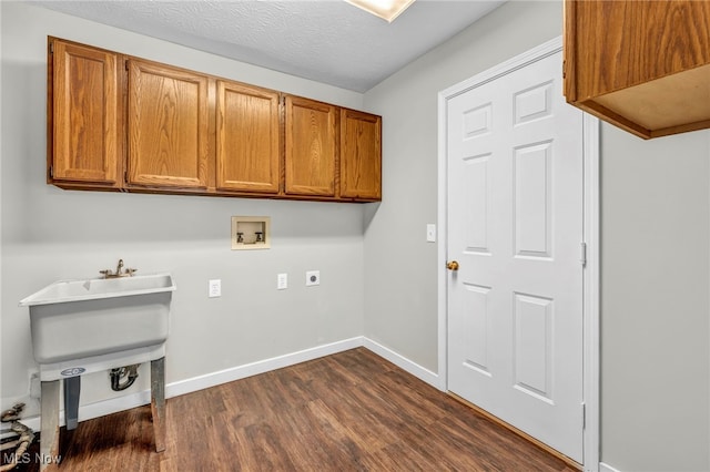 laundry area featuring dark hardwood / wood-style flooring, cabinets, washer hookup, hookup for an electric dryer, and a textured ceiling