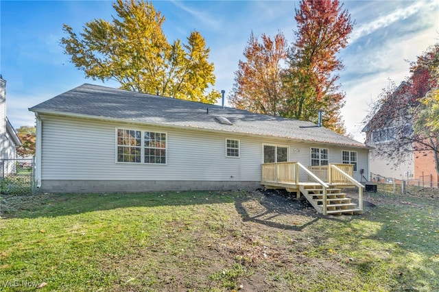 rear view of property with a deck and a lawn