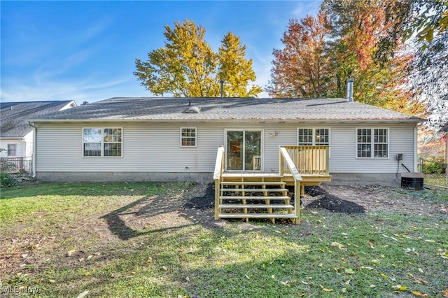 rear view of house with a wooden deck and a yard