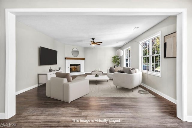 living room featuring ceiling fan and dark hardwood / wood-style flooring