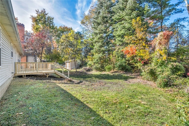 view of yard featuring a wooden deck and a shed