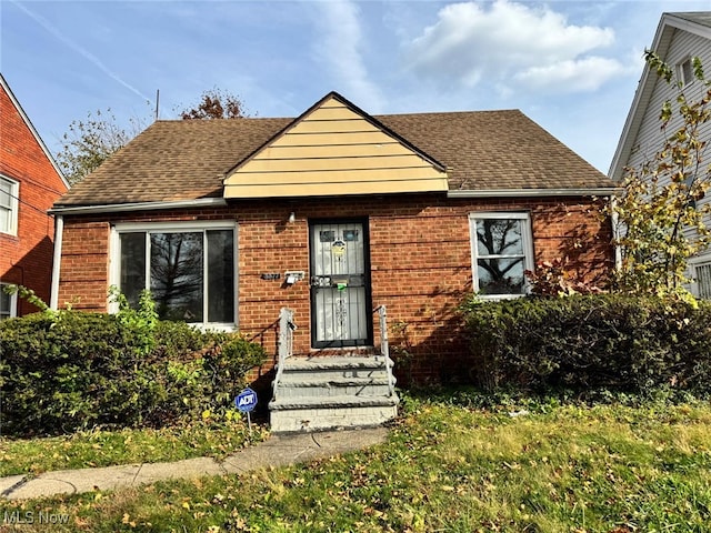 bungalow with brick siding and roof with shingles