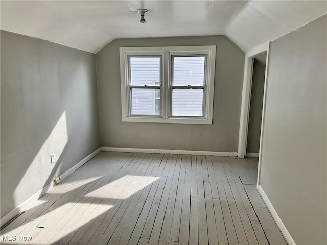 bonus room featuring baseboards, vaulted ceiling, and hardwood / wood-style flooring