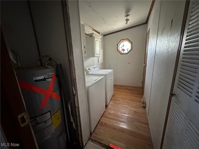 laundry area with cabinets, washer and dryer, light wood-type flooring, ornamental molding, and water heater