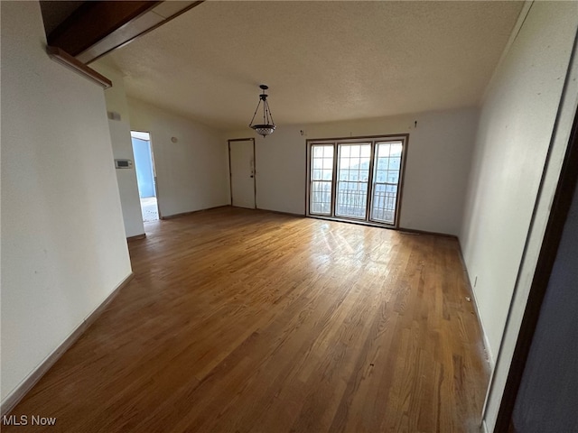 spare room with light hardwood / wood-style flooring and a textured ceiling