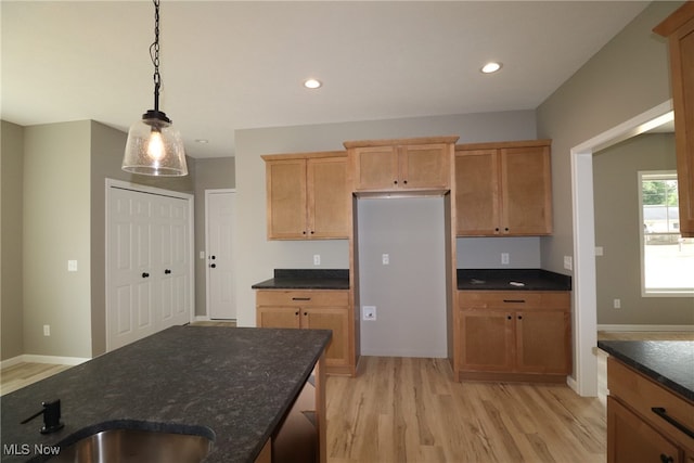 kitchen with sink, light wood-type flooring, and hanging light fixtures