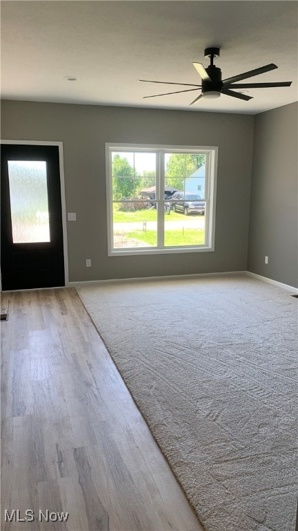 empty room with ceiling fan and light wood-type flooring