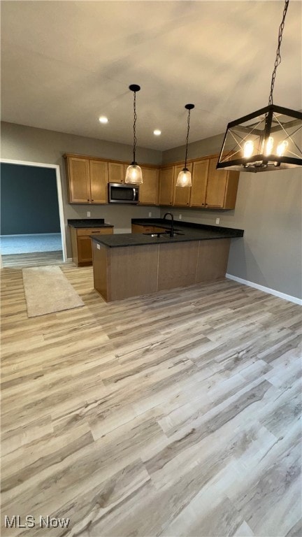 kitchen featuring a notable chandelier, light hardwood / wood-style flooring, and hanging light fixtures