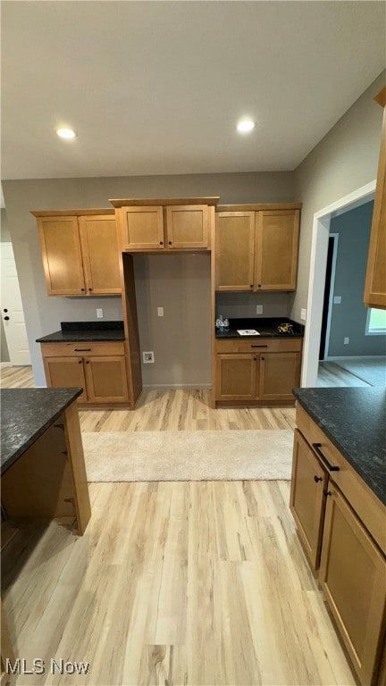 kitchen featuring dark stone countertops and light wood-type flooring