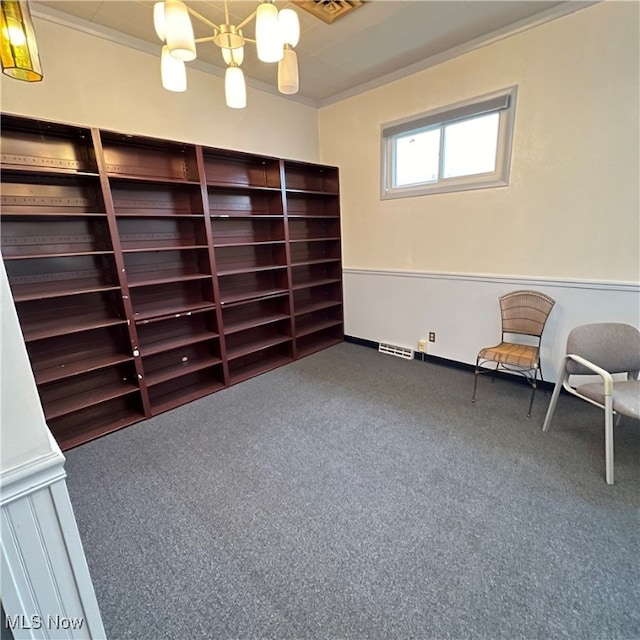 unfurnished room with an inviting chandelier, ornamental molding, and carpet