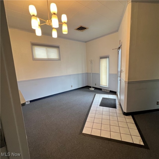 unfurnished room with a chandelier, crown molding, and light colored carpet