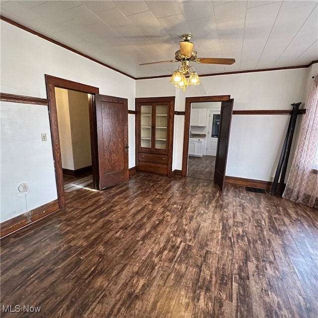 unfurnished room with ornamental molding, ceiling fan, and dark hardwood / wood-style flooring