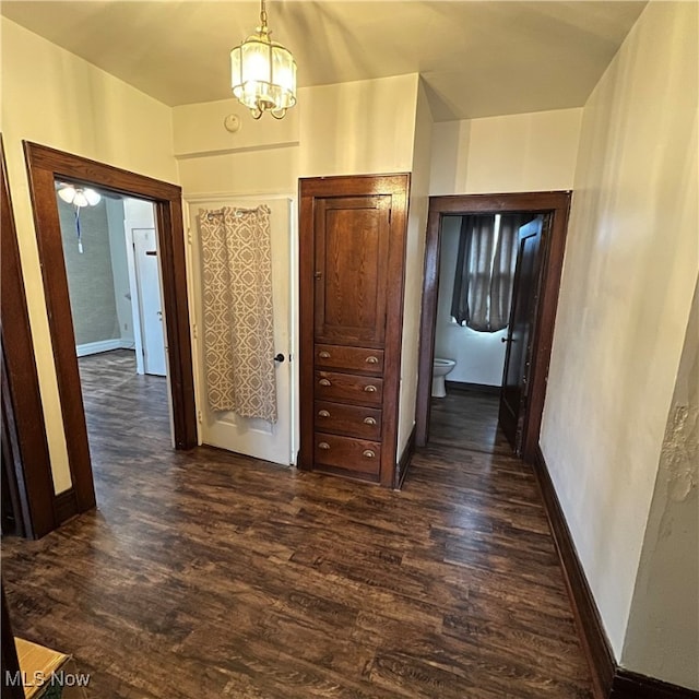 hall with a chandelier and dark hardwood / wood-style floors