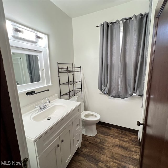 bathroom featuring vanity, wood-type flooring, and toilet