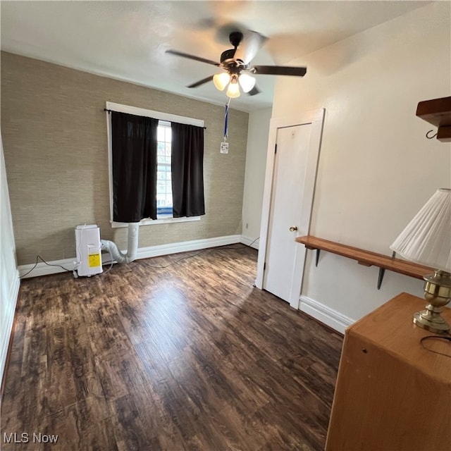 empty room with dark wood-type flooring and ceiling fan