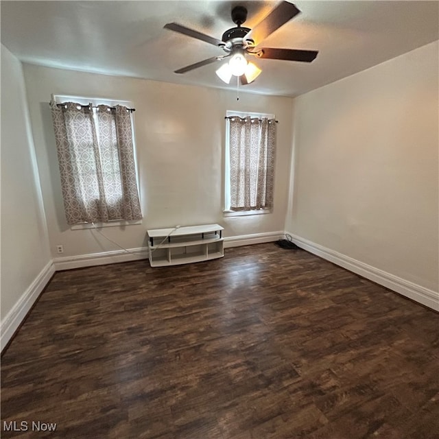 spare room featuring dark wood-type flooring and ceiling fan