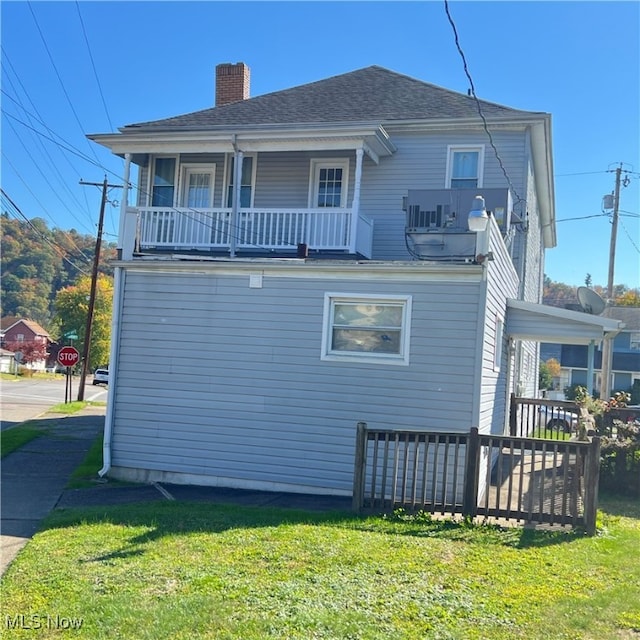 exterior space featuring a balcony and a yard