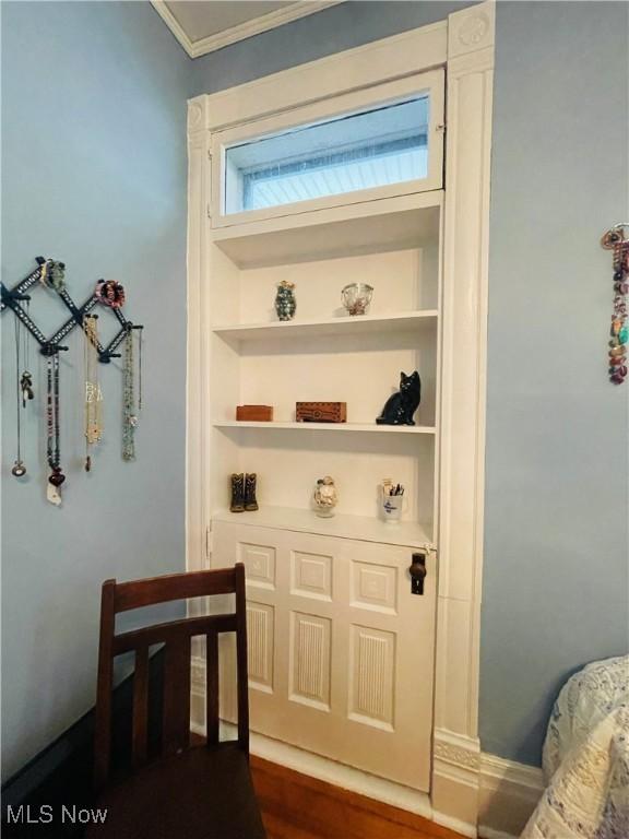 interior space featuring dark hardwood / wood-style flooring, crown molding, and built in features