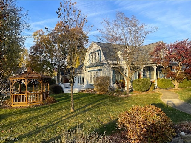 view of front of house with a front yard and a gazebo