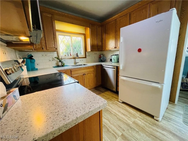 kitchen featuring backsplash, sink, stainless steel appliances, and light hardwood / wood-style floors