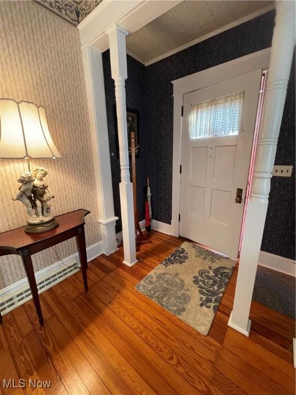 entryway with wood-type flooring and ornamental molding