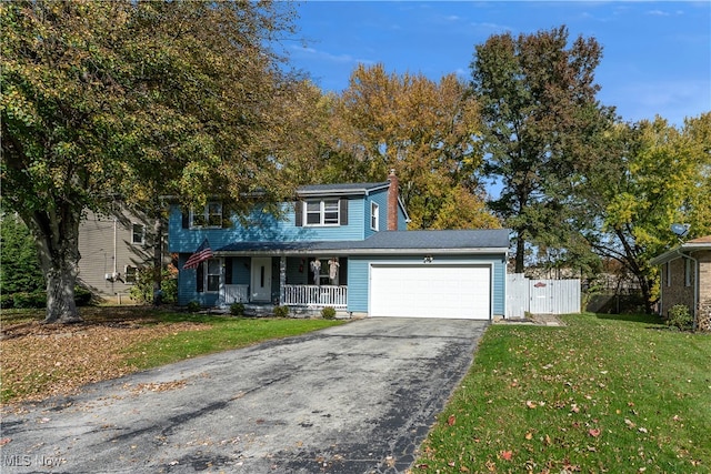 front of property with a garage, a front lawn, and a porch